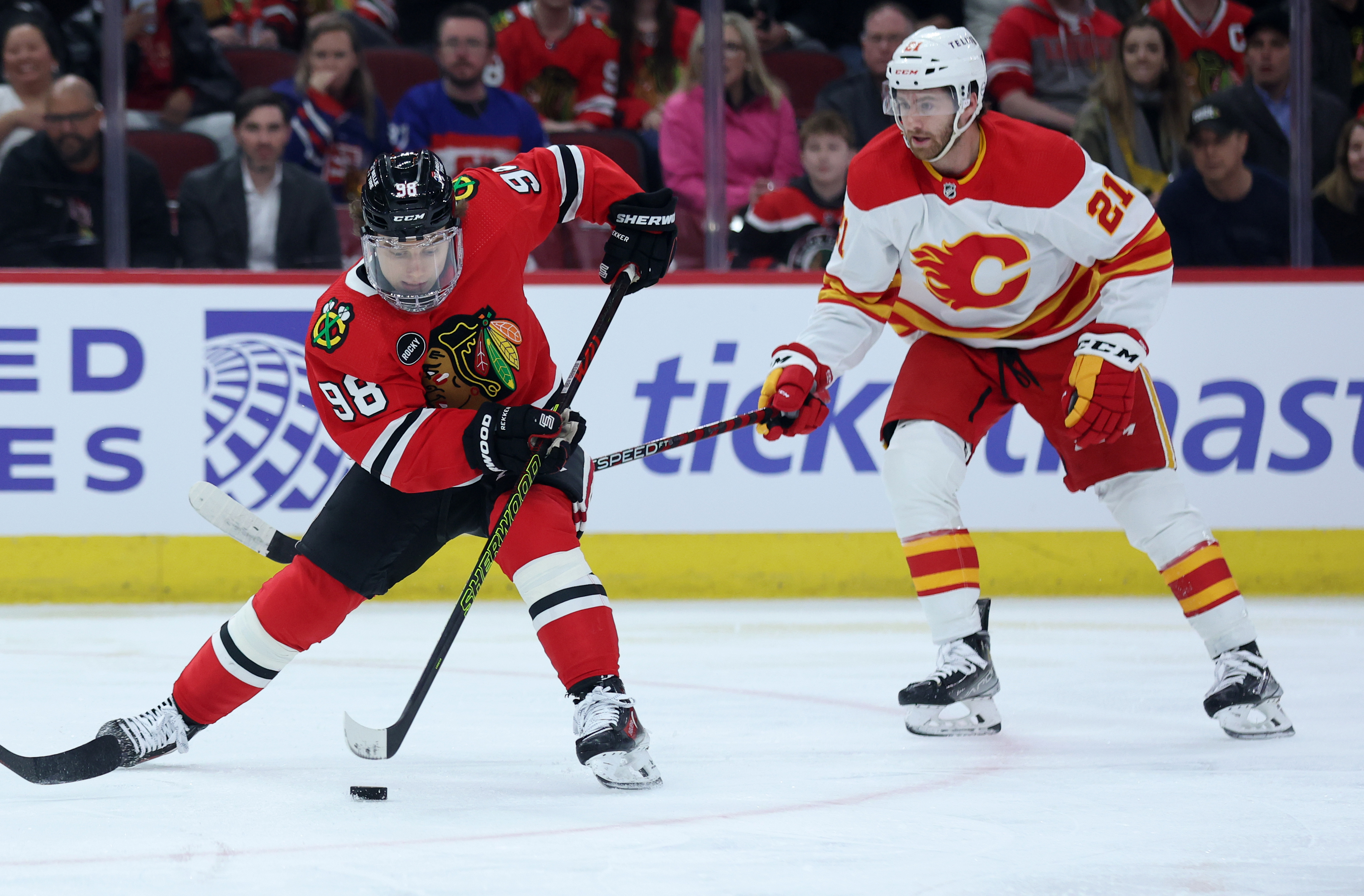 Chicago Blackhawks center Connor Bedard (98) makes a move in front of Calgary Flames center Kevin Rooney (21) in the first period of a game at the United Center in Chicago on March 26, 2024. (Chris Sweda/Chicago Tribune)