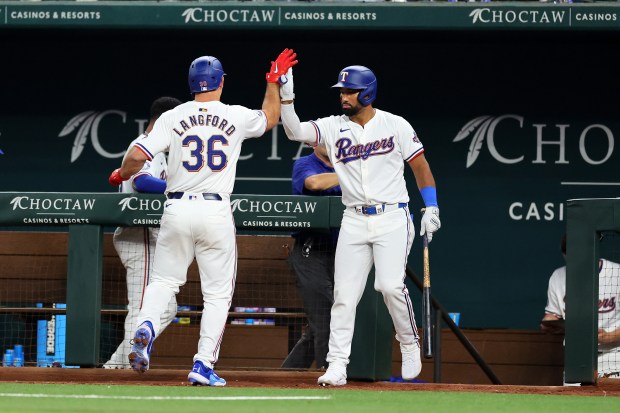 ARLINGTON, TEXAS - MARCH 28: Wyatt Langford #36 of the Texas Rangers is congratulated by Ezequiel Duran #20 following a sacrifice fly RBI against the Chicago Cubs during the fourth inning of the Opening Day game at Globe Life Field on March 28, 2024 in Arlington, Texas. (Photo by Stacy Revere/Getty Images)