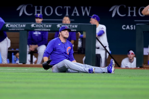 Chicago Cubs starting pitcher Justin Steele falls to the ground while holding his left leg during the fifth inning of the team's baseball game against the Texas Rangers, Thursday, March 28, 2024 in Arlington, Texas. (AP Photo/Gareth Patterson)