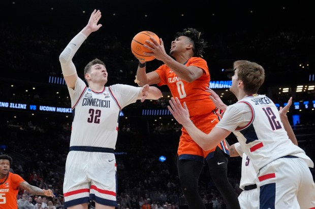 Illinois guard Terrence Shannon Jr. (0) is pressured by UConn center Donovan Clingan (32) while driving to the basket during the second half of the Elite 8 college basketball game in the men's NCAA Tournament, Saturday, March 30, 2024, in Boston. (AP Photo/Steven Senne)