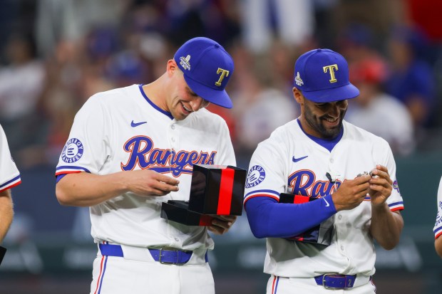 Rangers stars Corey Seager, left, and Marcus Semien review their World Series rings before a game against the Cubs on March 30, 2024, in Arlington, Texas. (Gareth Patterson/AP)