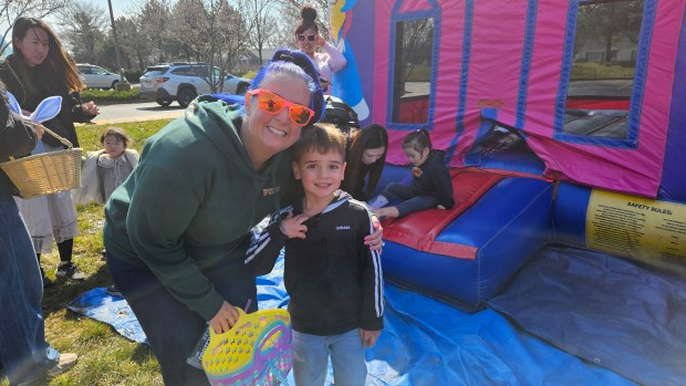 Michelle Wajda of Romeoville and her 5-year-old son Alex get ready to dash for some of the 14,000 eggs available Saturday morning during the annual Easter egg hunt offered by Faith Lutheran Church in Aurora. (David Sharos / For The Beacon-News)