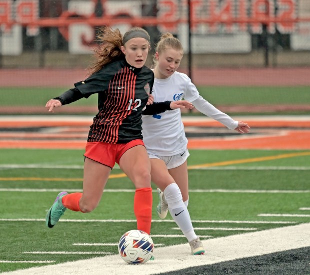 St. Charles East's Sophia Wollenberg beats Burlington Central's Ellie Elders to the ball. St. Charles East played Burlington Central to a 0-0 tie in girls soccer, Tuesday, March 26, 2024, in St. Charles, Illinois. (Jon Langham/for the Beacon-News)