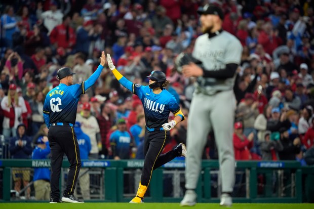 Phillies third baseman Alec Bohm, celebrates with coach Dusty Wathan after hitting a three-run home run off White Sox starter Garrett Crochet during the third inning on April 19, 2024, in Philadelphia. It was Bohm's second three-run shot of the game.(AP Photo/Matt Slocum)