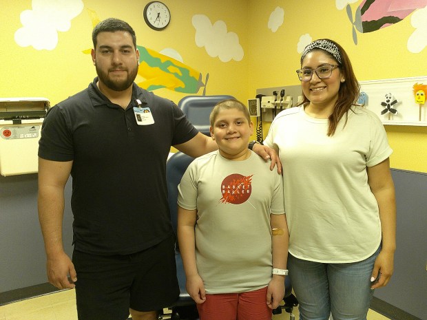 Emiliano Covarrubias, of West Beverly, stands with his dad, Xavier Covarrubias, and mom, Maricela Suarez, during a recent checkup visit at Advocate Children's Hospital in Oak Lawn, where he demonstrated a virtual reality system that helped him endure chemotherapy treatments. (Susan DeGrane/Daily Southtown)