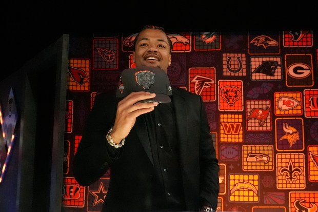 Washington wide receiver Rome Odunze puts on a hat after being chosen by the Chicago Bears with the ninth overall pick during the first round of the NFL football draft, Thursday, April 25, 2024, in Detroit. (AP Photo/Jeff Roberson)