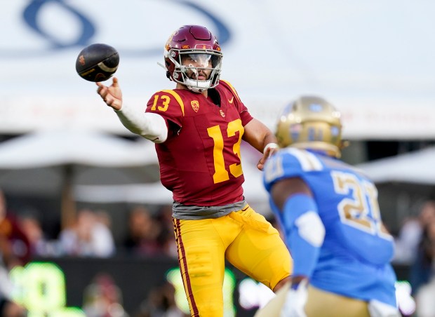 USC quarterback Caleb Williams, left, throws a pass as UCLA linebacker JonJon Vaughns watches on Nov. 18, 2023, in Los Angeles. (Ryan Sun/AP)