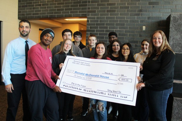 Caitlin Nelson, right, of the Oak Lawn Ronald McDonald House, stands with members of the Rotary Interact Club at Richards High School, who helped $600 through the Pi Day fund raiser. (Bob McParland)