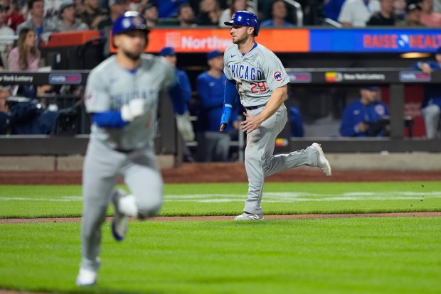 Chicago Cubs' Michael Busch (29) runs to home plate to score as Cubs' Nick Madrigal, left, runs to first base during the eighth inning of a baseball game against the New York Mets, Monday, April 29, 2024, in New York. (AP Photo/Frank Franklin II)