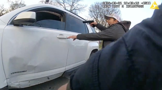 A still image of a video released by the Civilian Office of Police Accountability shows a group of Chicago police officers surrounding a vehicle driven by Dexter Reed, 26, moments before an "exchange of gunfire" in which Reed was fatally shot on March 21, 2024 in the Humboldt Park neighborhood. (Chicago Police Department)