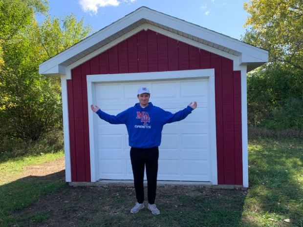 Chris Eby, 17, of Sugar Grove, shows off the completed storage shed he and over 60 volunteers helped build last summer for Sugar Grove United Methodist Church. (Eby family)