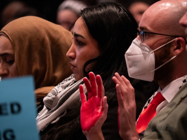 An audience member holds up hands painted in red at the Naperville City Council meeting April 2, 2024 in Naperville. Since February, community members from Naperville and surrounding suburbs have turned out at council meetings to request that that Naperville elected officials issue a resolution calling for a permanent ceasefire in the ongoing war between Israel and Hamas in Gaza. (Tess Kenny/Naperville Sun)