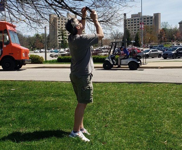 Patrick Parrish of Lexington, Kentucky takes photos of the eclipse using a special filter for his smartphone at Indiana University in Bloomington. (Carrie Napoleon/Post-Tribune)