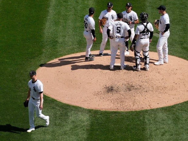 Chicago White Sox starting pitcher Michael Soroka, left, walks to the dugout after turning the ball over to manager Pedro Grifol (5) during the fifth inning of a baseball game against the Cincinnati Reds in Chicago, Sunday, April 14, 2024. (AP Photo/Nam Y. Huh)