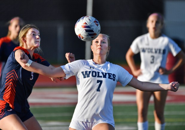 Oswego East's Gabby McPhee (7) moves to the ball as Oswego's Aubrey Eirich (left) defends during their Class 3A Lockport Regional semifinal game on Wednesday, May 15, 2024, in Lockport.(Jon Cunningham/for The Beacon-News)