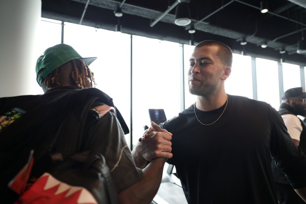 Athletes They Fear founder Kofi Hughes, right, greets Green Bay Packers wide receiver Jayden Reed as Reed joins Hughes and student-athletes for a workout on April 10, 2024, in Chicago. Reed began training with Hughes in high school, and their friendship continues. (John J. Kim/Chicago Tribune)