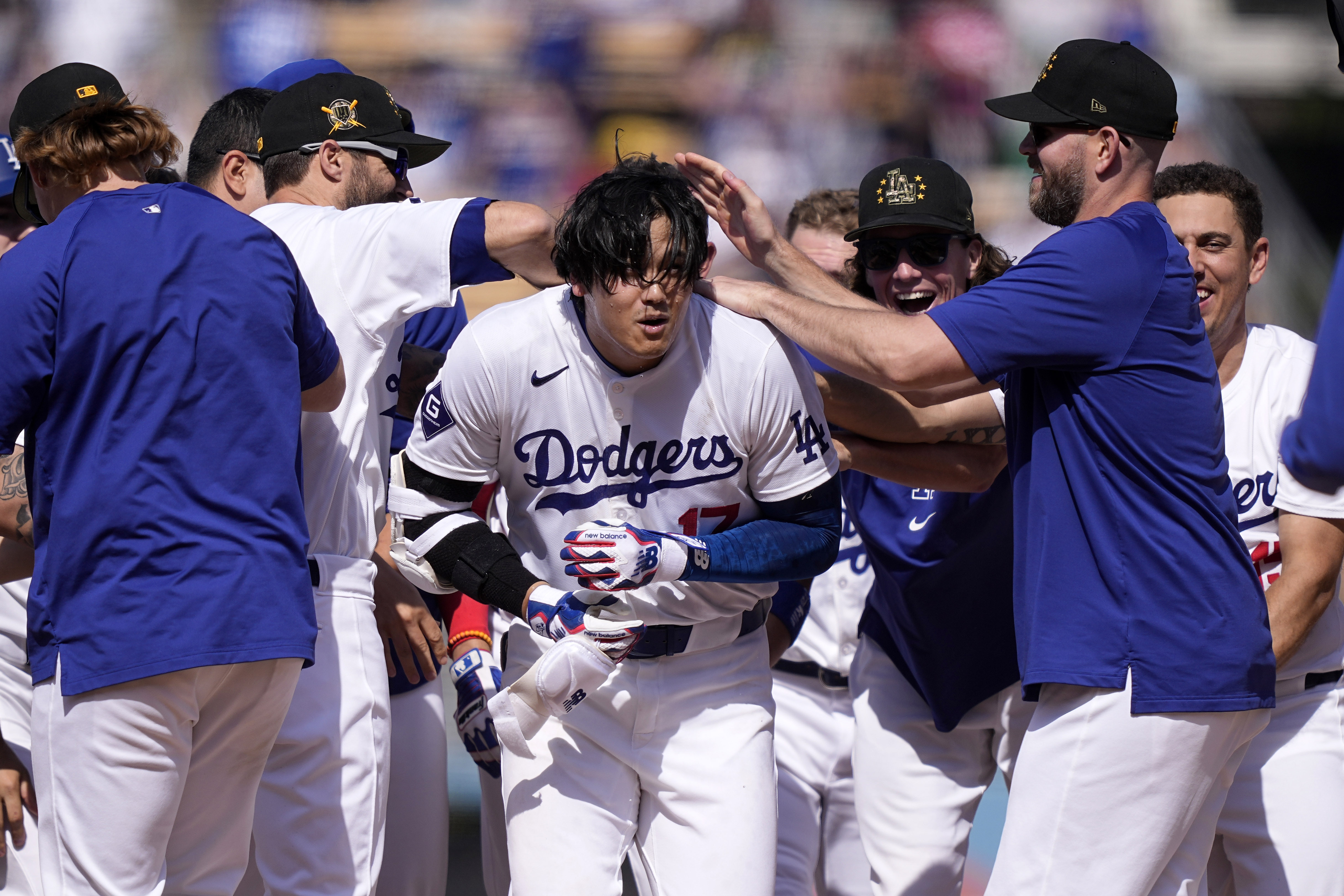 Los Angeles Dodgers’ Shohei Ohtani, center, is congratulated by teammates...