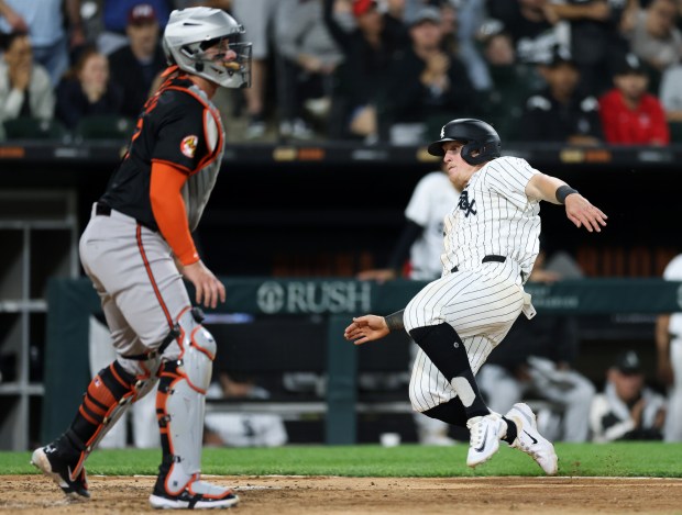 White Sox first baseman Andrew Vaughn (25), right, slides toward home plate on a two-run single hit by shortstop Paul DeJong in the fifth inning against the Orioles at Guaranteed Rate Field on May 24, 2024, in Chicago. (John J. Kim/Chicago Tribune)