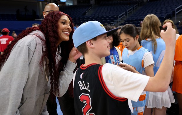 Injured Sky center Kamilla Cardoso poses for a picture with a young fan before the home opener against the Connecticut Sun on May 25, 2024, at Wintrust Arena. (Chris Sweda/Chicago Tribune)