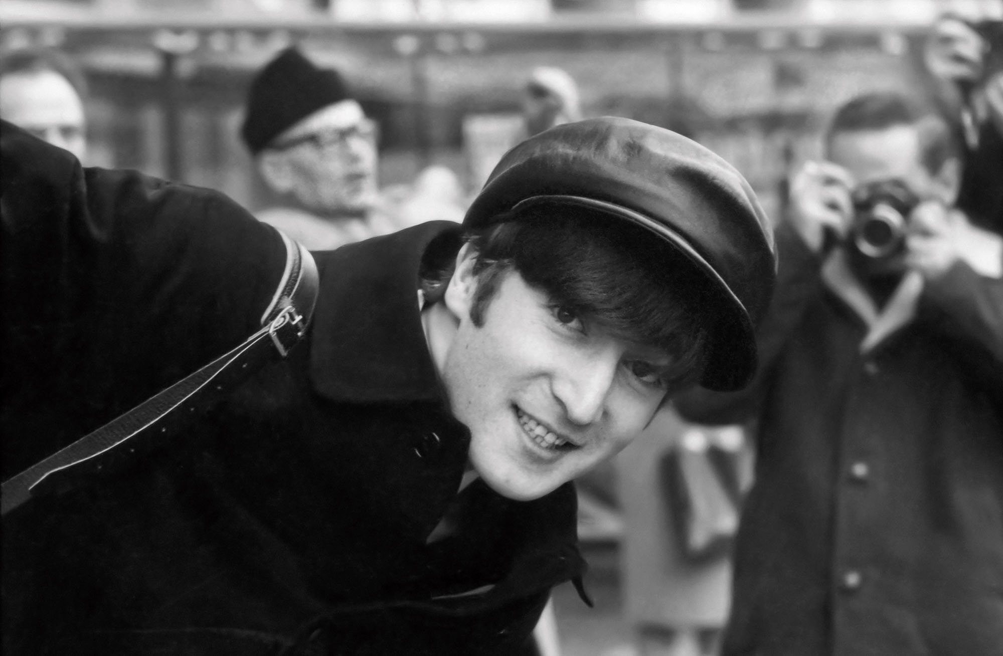 A black and white photograph of a man wearing a hat