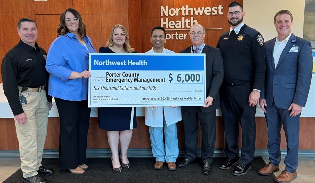 Northwest Health - Porter staff and visitors gather for the Doctors' Day donation ceremony, including, from left, Lance Bella, Director for the Porter County Emergency Management Agency; Debby Gunn, Executive Director for Porter County Central Communications; Sarah Hunter, Chief Operating Officer for Northwest Health Porter; Dr. Vivek Mishra, president-elect of the Medical Staff at Northwest Health Porter; Dr. Joseph Venditti, president of the Medical Staff at Northwest Health Porter; Aric Homberg, Director for Northwest Health EMS; and Dr. James Leonard, Chief Executive Officer for Northwest Health Porter. (Photo courtesy of Northwest Health Porter)