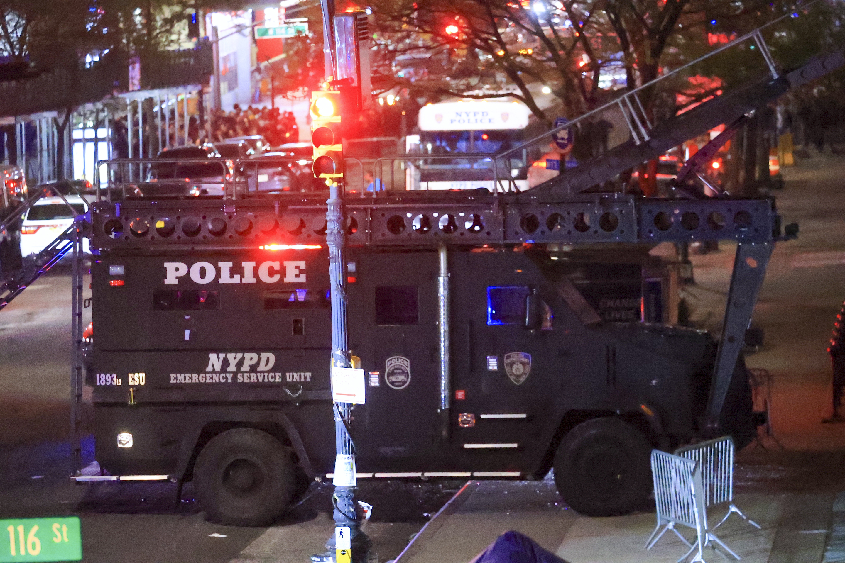 A mine-resistant NYPD truck smashes a glass bus stop shelter before breaching a Columbia building