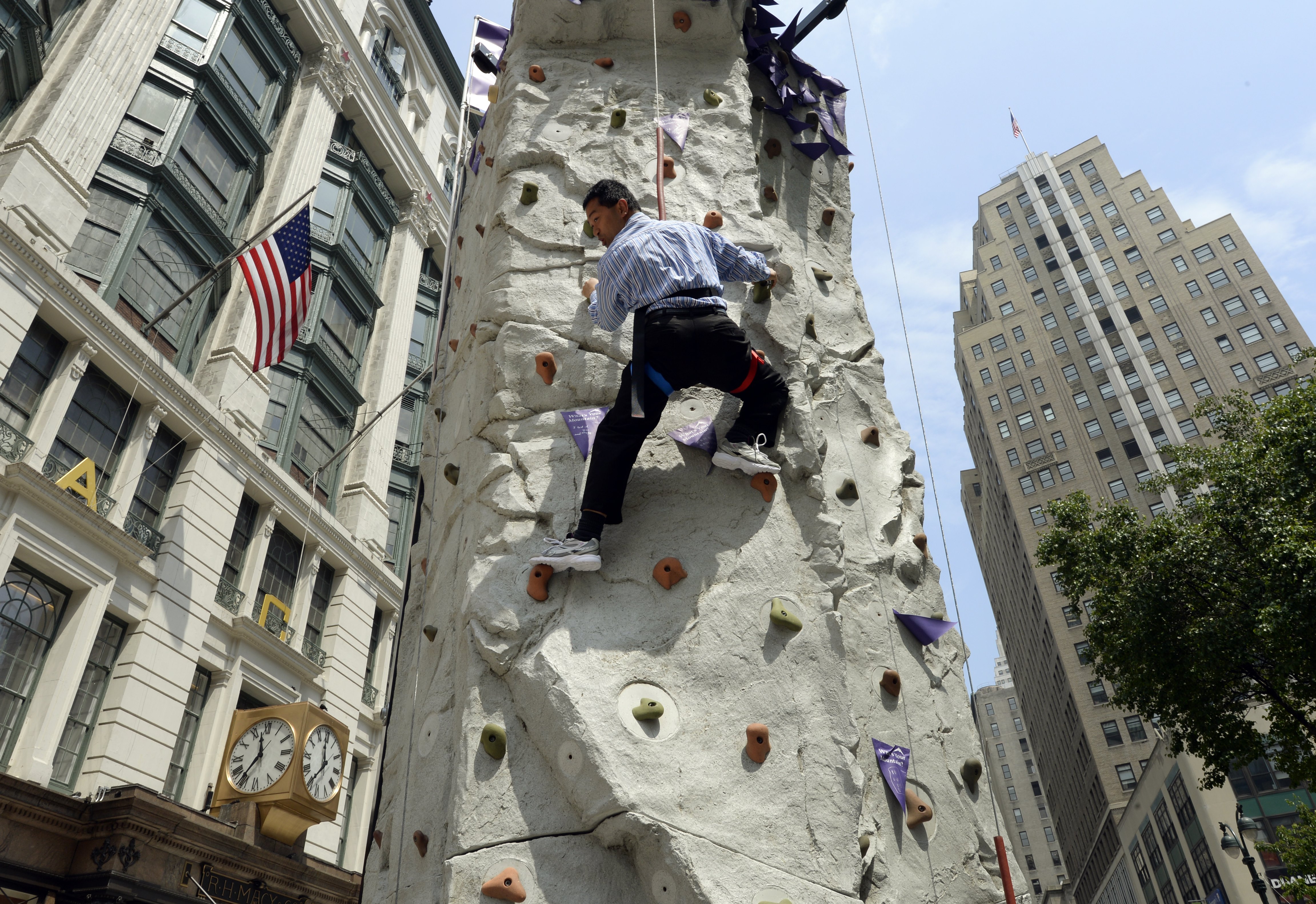 a man climbs a wall in Manhattan set up to honor the anniversary of the first climbing of mount everest