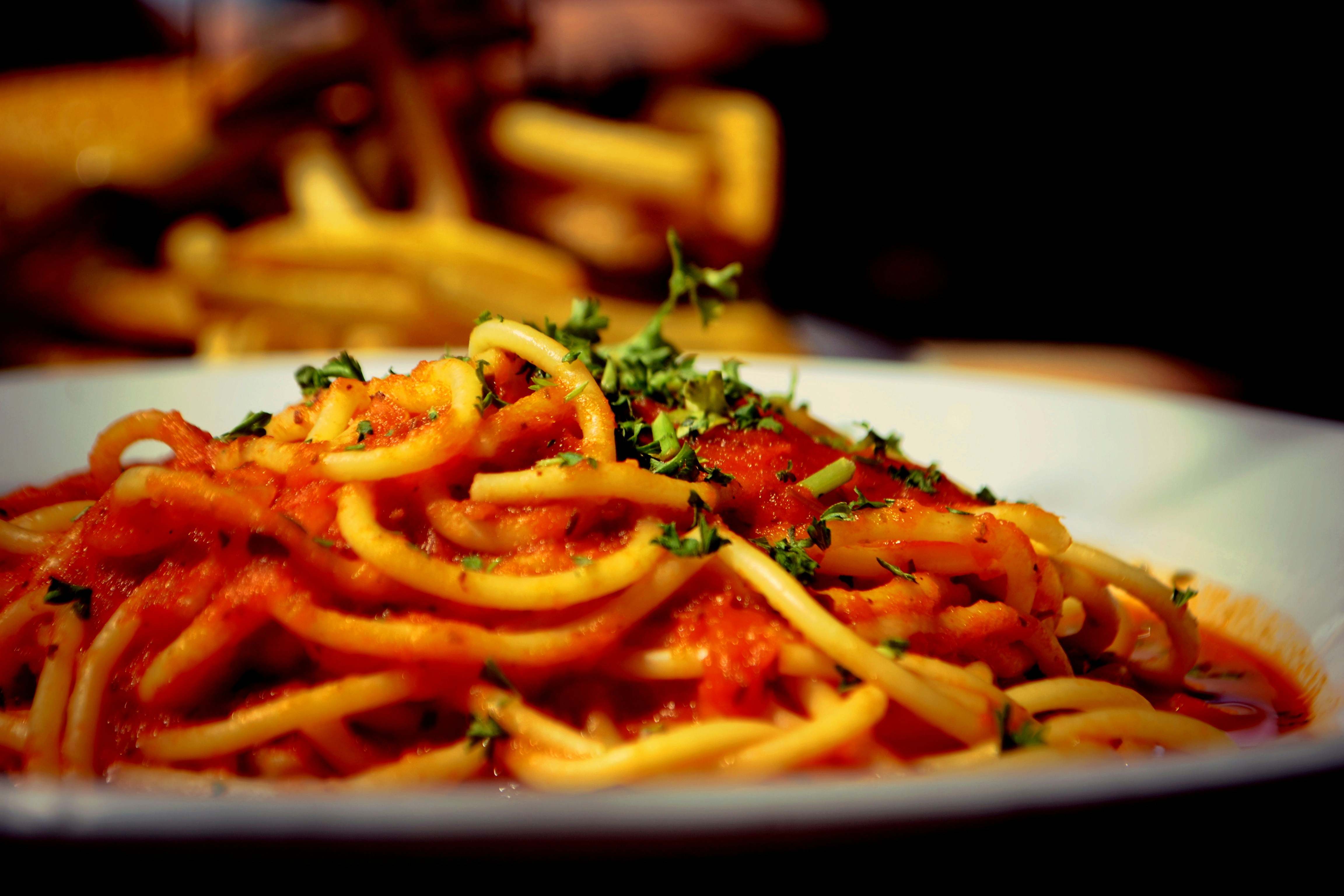 A bowl of pasta with marinara sauce.