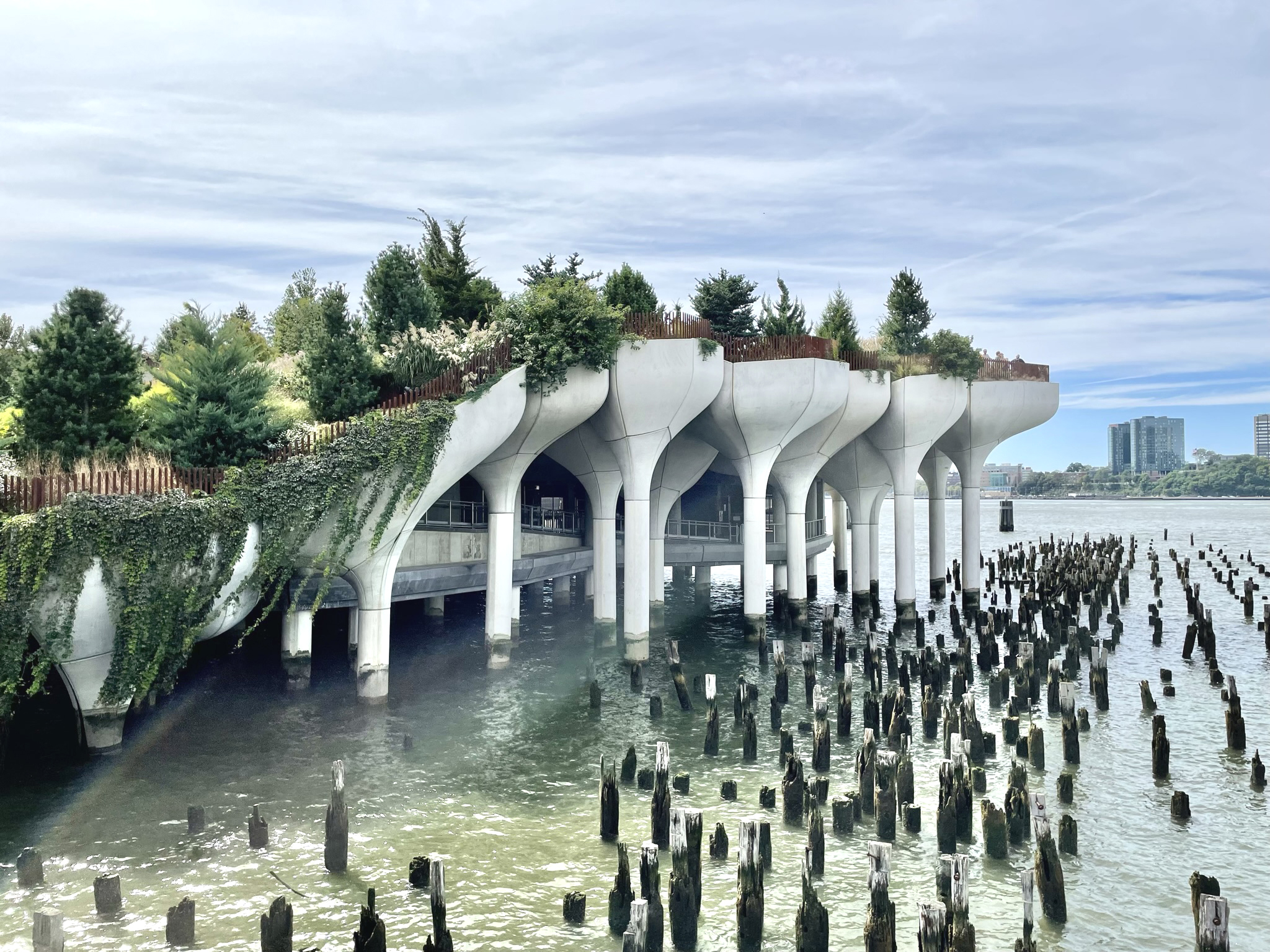 A picture of a manmade island lined with plants and with the river in the background.