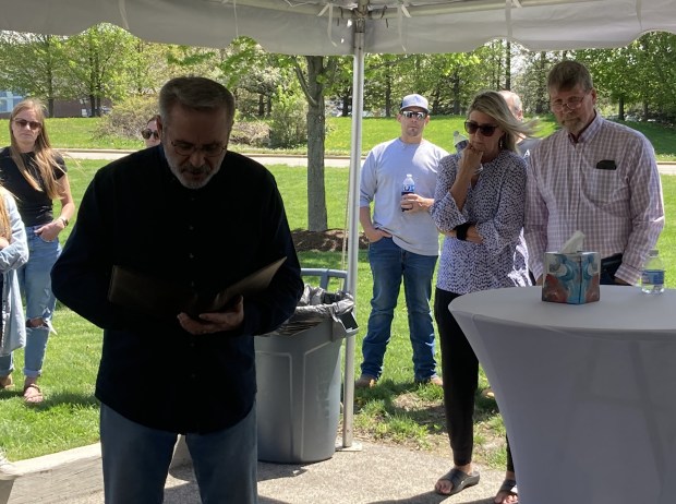 The Rev. Dave Adams, pastor of New Song Ministries in Zion, speaks as Mac Penman and Stephanie Penman listen behind him. (Steve Sadin/Lake County News-Sun)