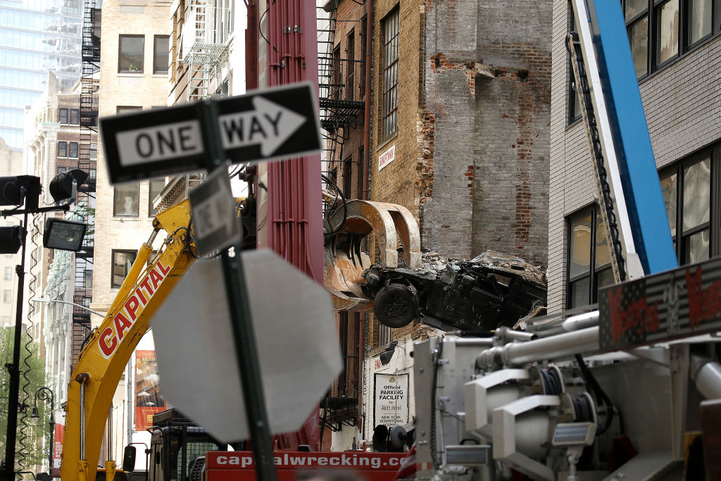 An excavator extracts a vehicle from a collapsed parking garage in Lower Manhattan on April 19, 2023.