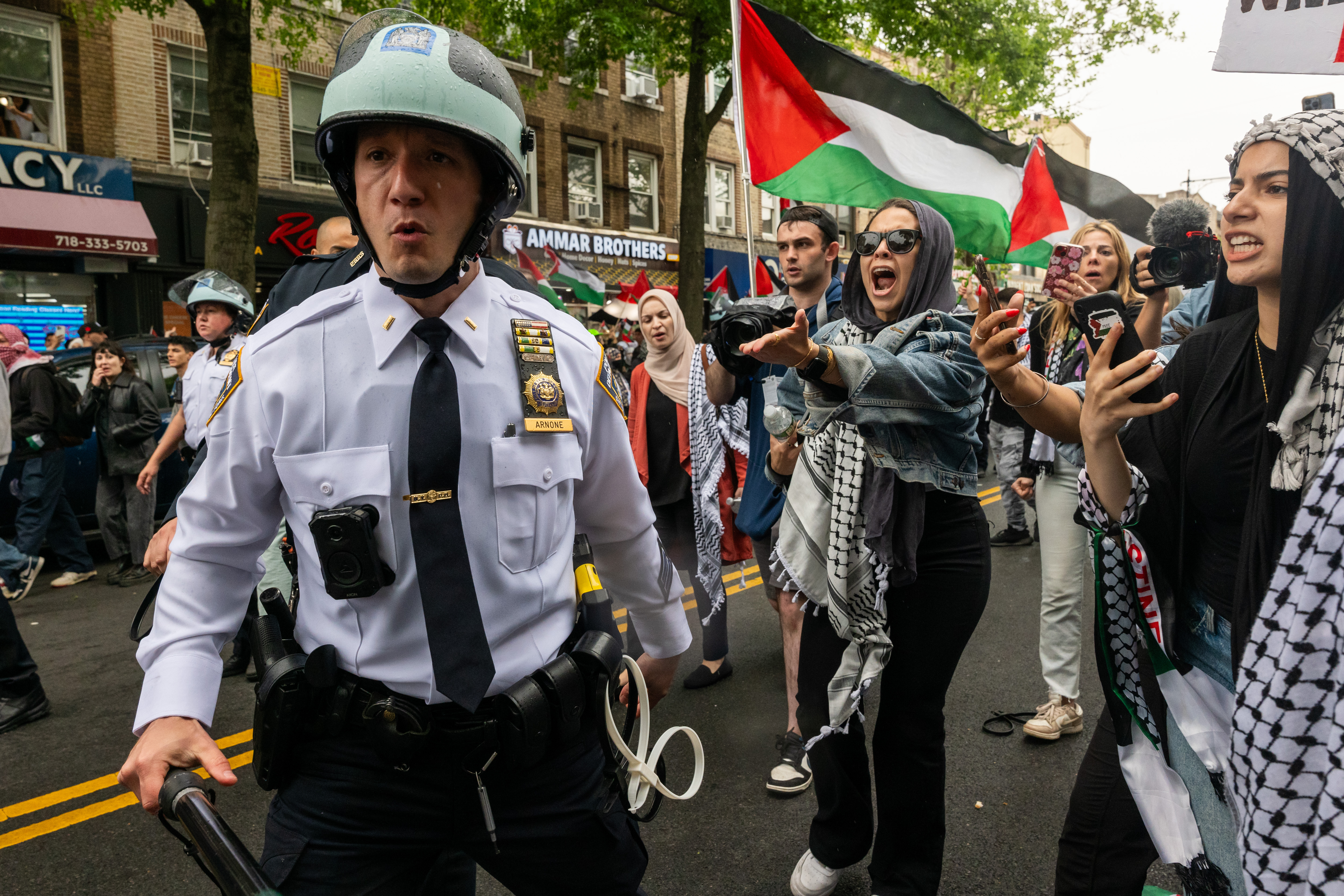 Protesters jeer a police officer.