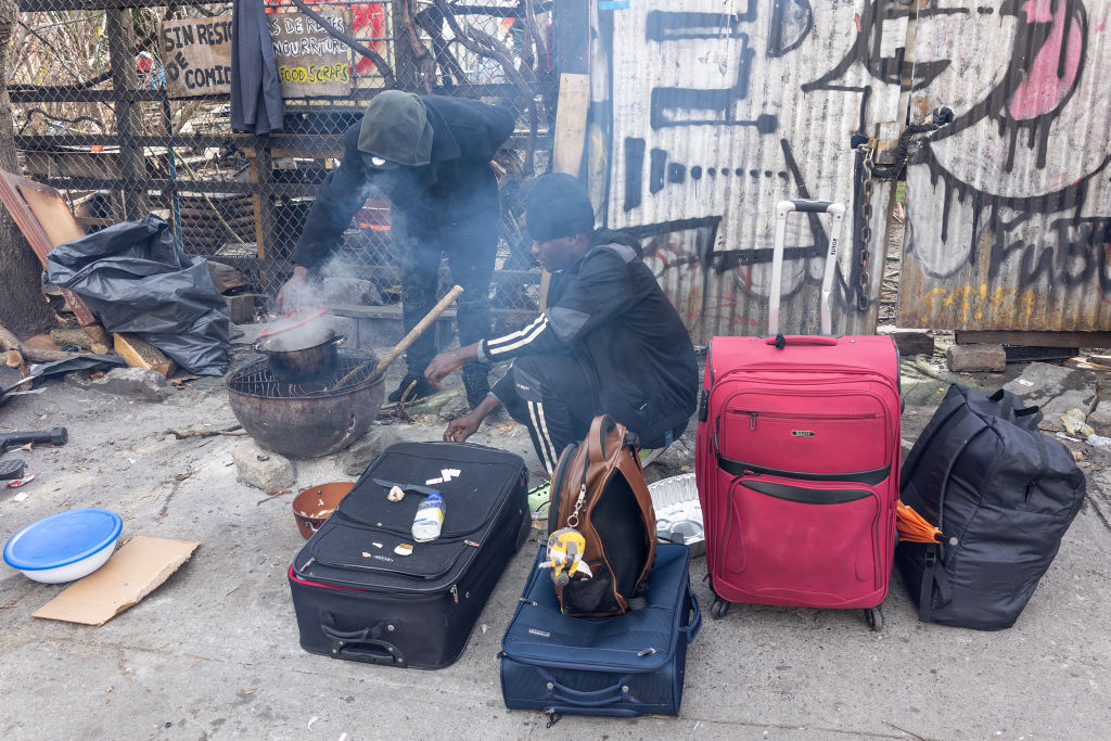 Newly arrived migrants from West Africa cook a meal on the street on January 14, 2024 in the Bedford Stuyvesant neighborhood of Brooklyn, New York.