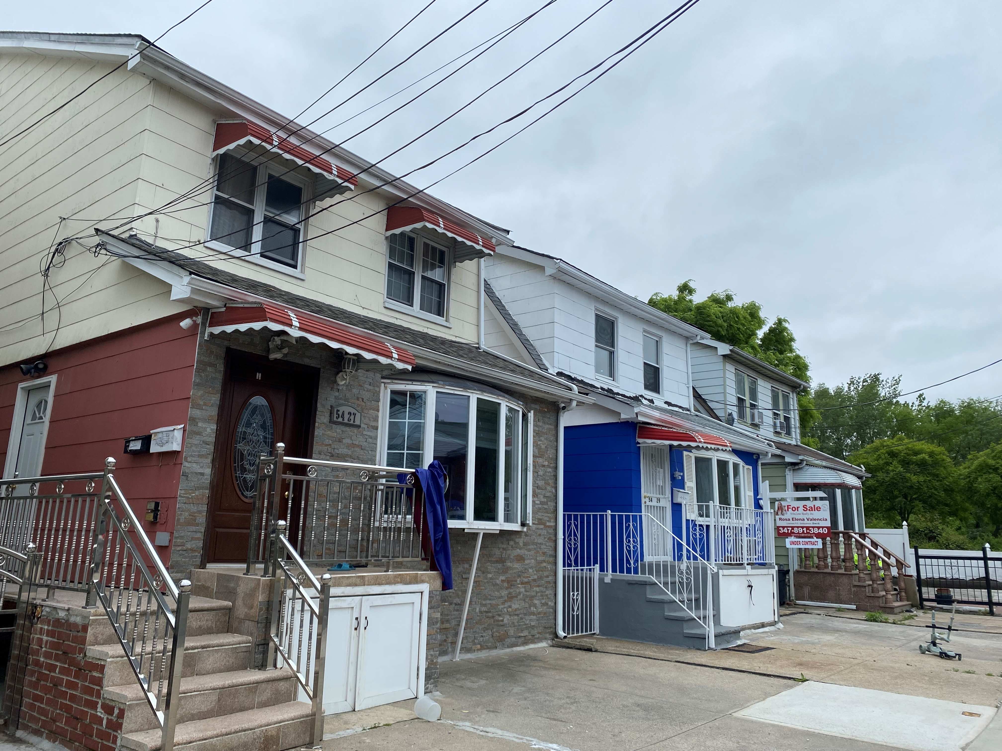 A row of houses near Kissena Park, one of which has a for sale sign