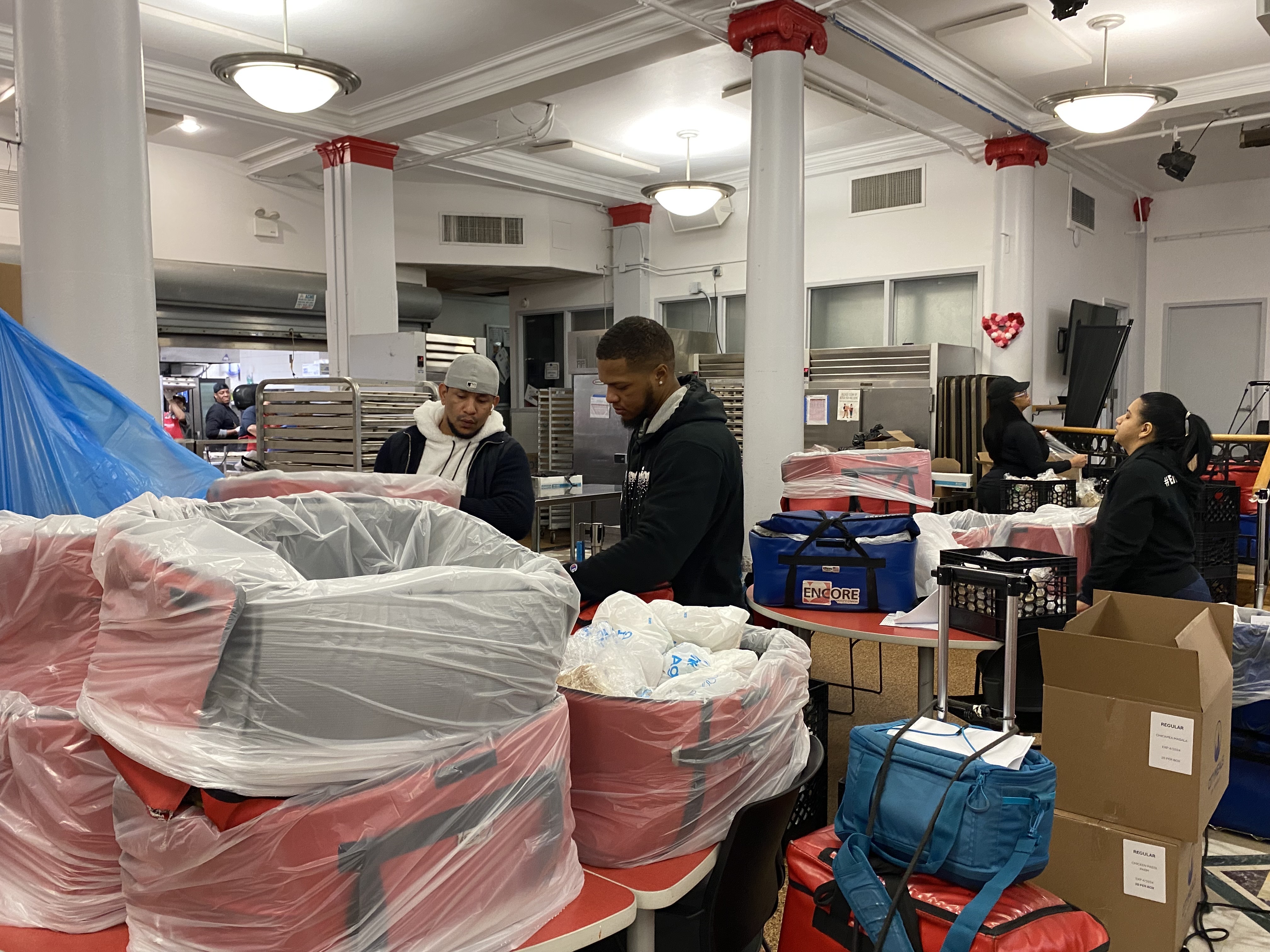 Workers at Encore Community Services pack up insulated bags with food.