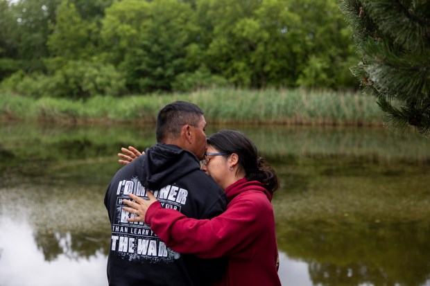 Panita Luangkesorn, right, comforts her husband, Ryan Killacky, a veteran who served in Afghanistan, after he became emotional during the annual Rosehill Memorial Day cemetery ceremony on May 27, 2024, at Rosehill Cemetery in Chicago. (Vincent Alban/Chicago Tribune)