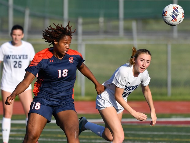 Oswego East's Morgan Dick (right) and Oswego's Jordyn Washington (18) race to the the ball during their Class 3A Lockport Regional semifinal game on Wednesday, May 15, 2024, in Lockport.(Jon Cunningham/for The Beacon-News)