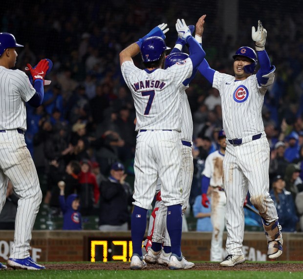 Chicago Cubs right fielder Seiya Suzuki (right) is congratulated by teammates, including Dansby Swanson (7), after Suzuki hit a grand slam in the second inning of a game against the Cincinnati Reds at Wrigley Field in Chicago on June 1, 2024. (Chris Sweda/Chicago Tribune)