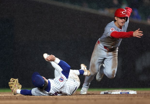 Cincinnati Reds baserunner Stuart Fairchild takes off from second base after Chicago Cubs second baseman Nico Hoerner (2) was unable to handle a wide throw from Christopher Morel in the fourth inning of a game at Wrigley Field in Chicago on June 1, 2024. (Chris Sweda/Chicago Tribune)