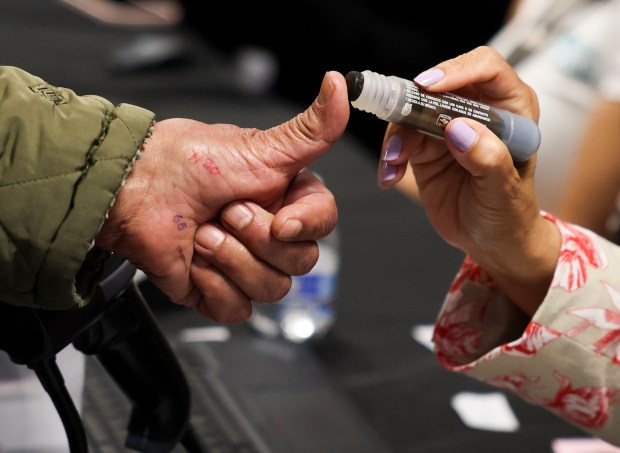 An election official marks the thumbs of a voter with ink after they voted in the Mexican presidential election at the Consulate General of Mexico in Chicago on June 2, 2024. (Eileen T. Meslar/Chicago Tribune)