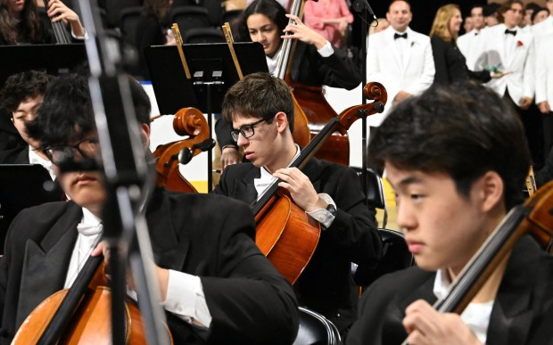 Center, Ethan Fogelson, a junior of Wilmette, performs on cello with the New Trier Symphony Orchestra at the 124th annual New Trier Township High School commencement on June 2, 2024 at NOW Arena in Hoffman Estates. (Karie Angell Luc/Pioneer Press)