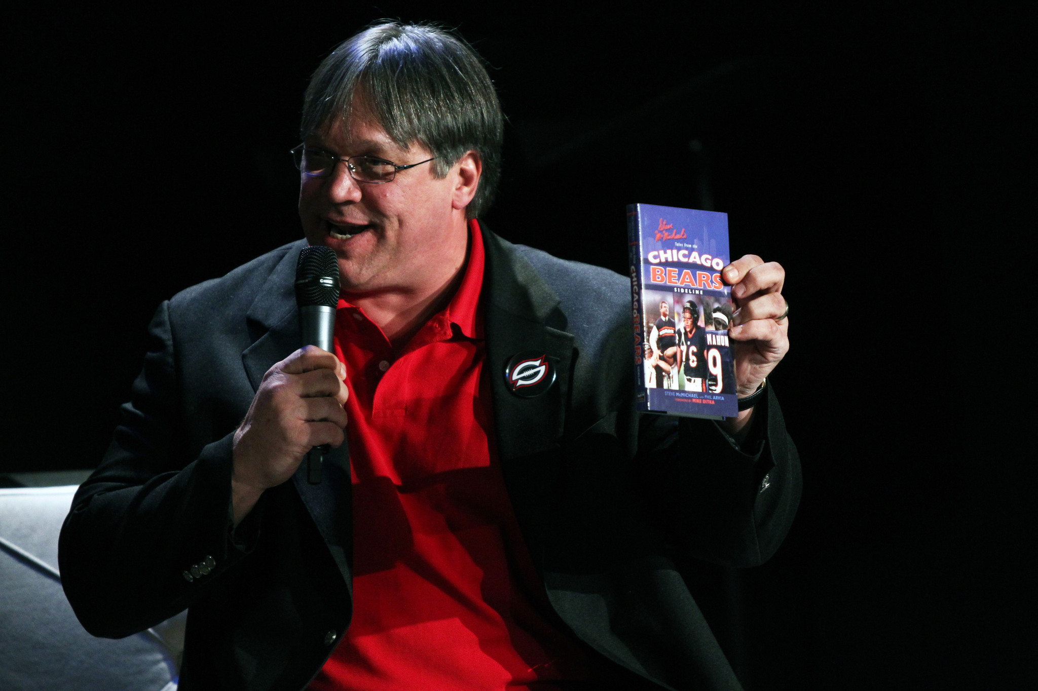 Steve McMichael shows off a copy of his book on...