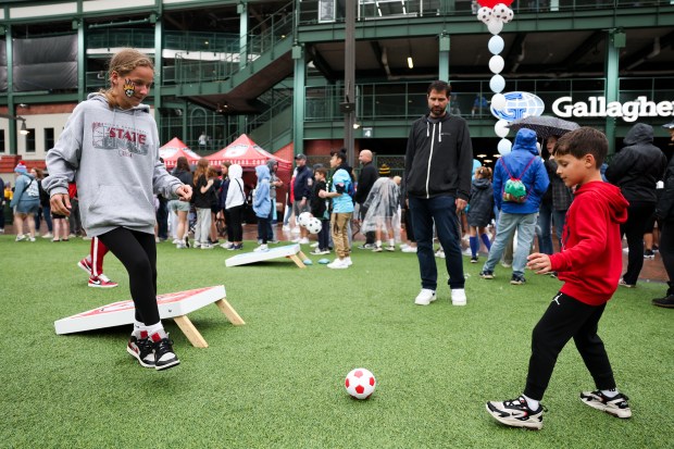 Elena Vlahos and her brother Teddy Vlahos play soccer on Gallagher Way before the Chicago Red Stars game against Bay FC at Wrigley Field on June 8, 2024. (Eileen T. Meslar/Chicago Tribune)