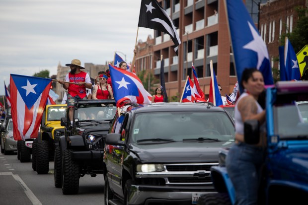 Parade attendees participate in a car caravan on W North Ave. during the 46th Puerto Rican People's Day Parade on June 8, 2024, in Humboldt Park in Chicago. (Vincent Alban/Chicago Tribune)