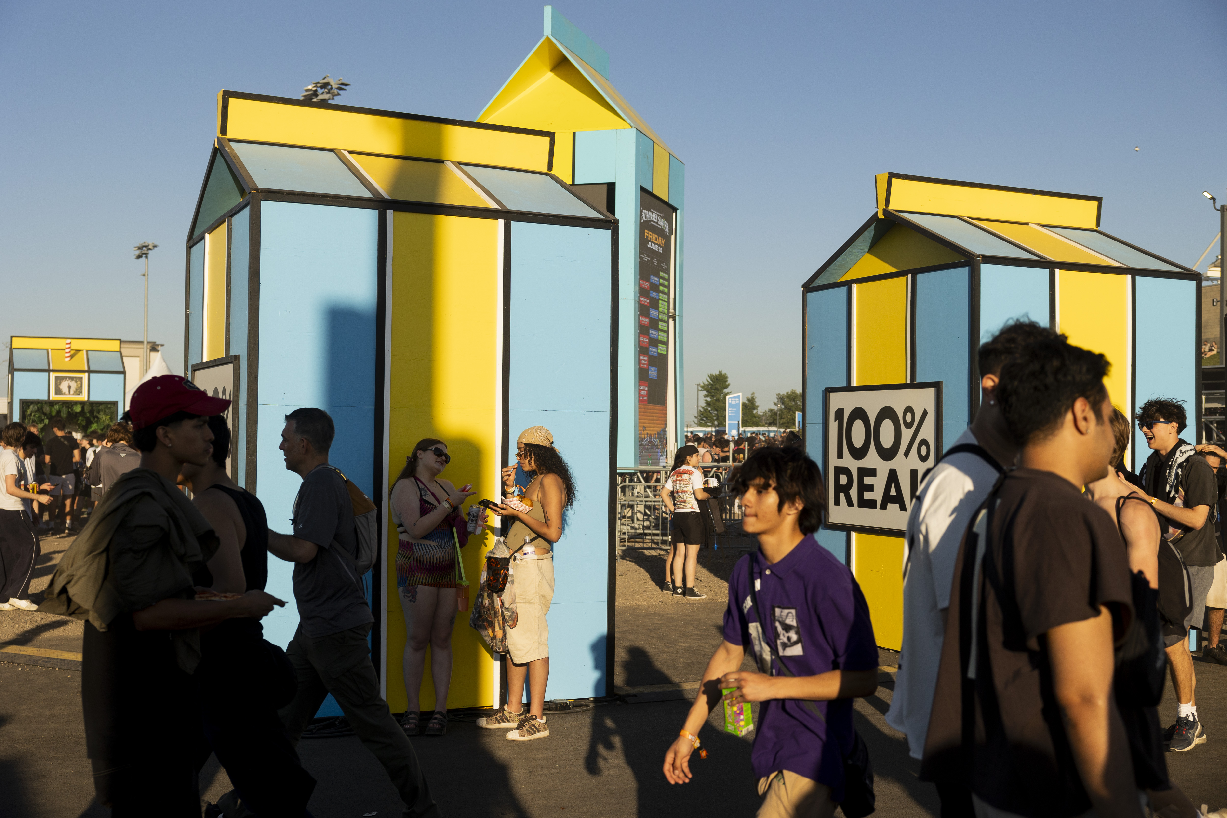 Festival attendees walk through the festival grounds on June 14,...