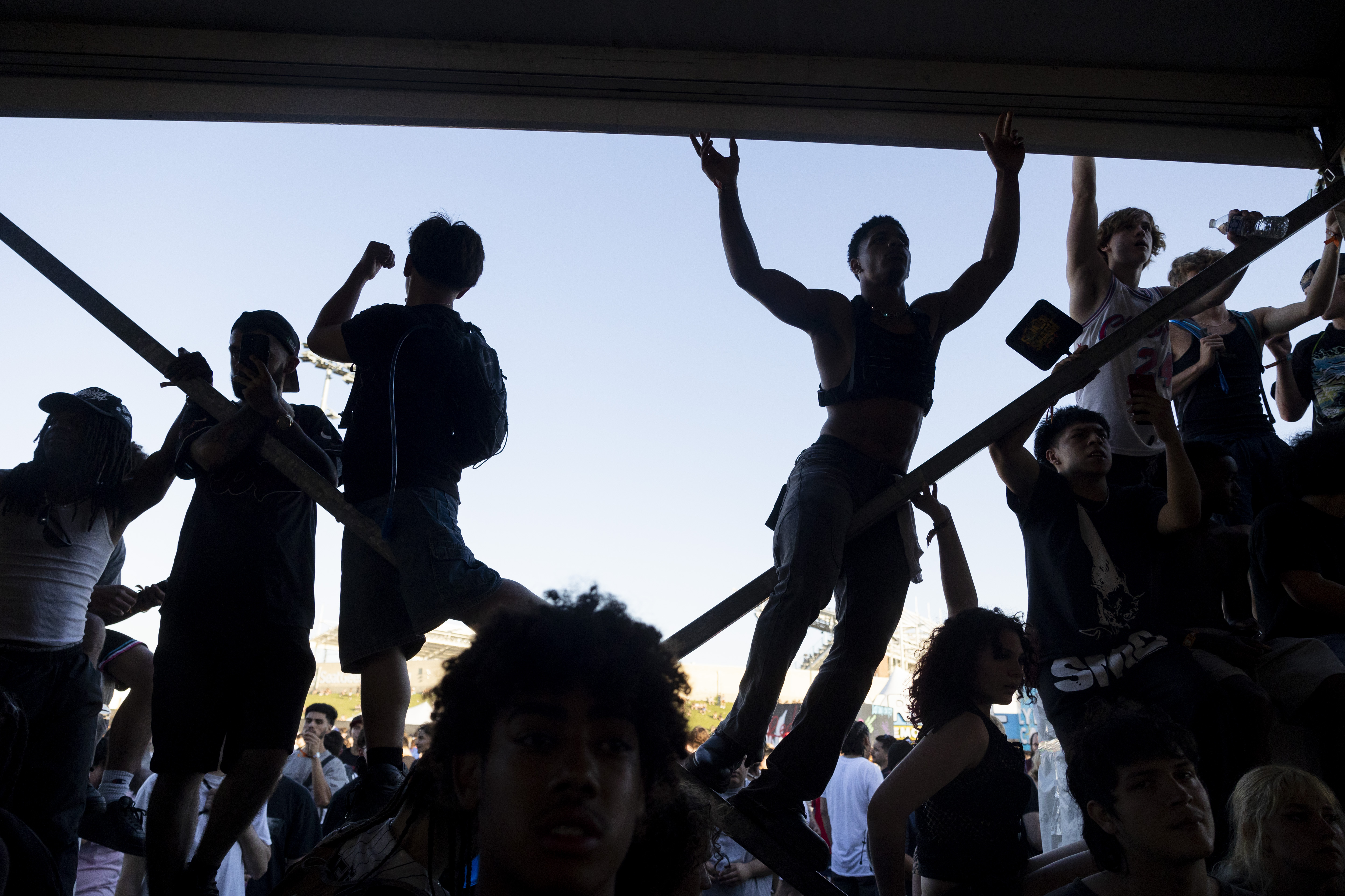 Festival attendees climb the post of the “Drink Lyrical” tent...