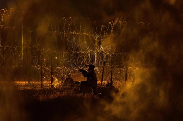 FILE A man tries to cut a hole in the concertina wire fence constructed along the U.S.-Mexico border in Ciudad Juarez, Mexico, on Tuesday, June 4, 2024. Migrants who unlawfully cross the border typically have to return to their country of origin to apply for a green card. (Paul Ratje/The New York Times)