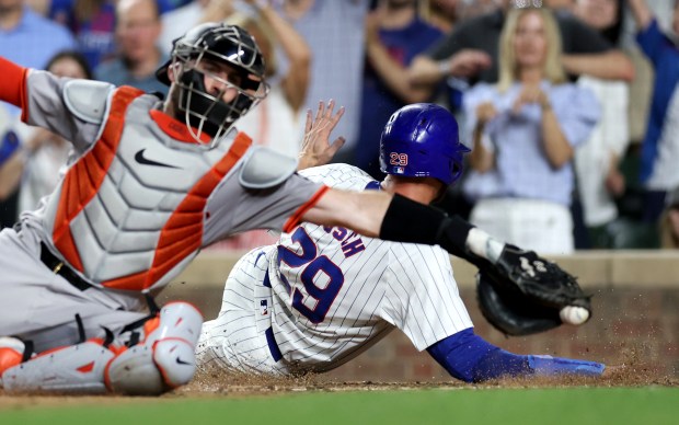 Chicago Cubs first baseman Michael Busch (29) slides in safely at home on a single by Cody Bellinger in the 8th inning of a game against the San Francisco Giants at Wrigley Field in Chicago on June 18, 2024. (Chris Sweda/Chicago Tribune)