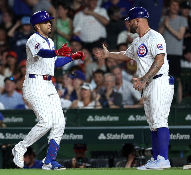 Chicago Cubs hitter Christopher Morel (left) celebrates after driving in a run on an infield single in the 8th inning of a game against the San Francisco Giants at Wrigley Field in Chicago on June 18, 2024. (Chris Sweda/Chicago Tribune)