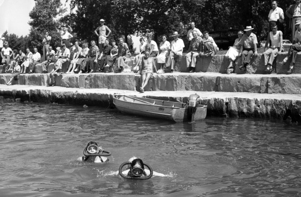 Volunteer divers Robert Domkowski, left, and Chuck Napravnik, right, search Lake Michigan for three missing bodies at Montrose Harbor after a large wave hit the lakefront on June 26, 1954. Eight people died when the killer wave swept them off the lakefront. (Chicago Tribune historical photo)